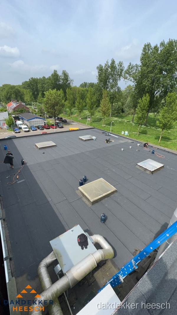 Dakdekker aan het werk op groot plat dak met bitumen in Heesch Dakdekker aan het werk op groot plat dak met bitumen in Heesch